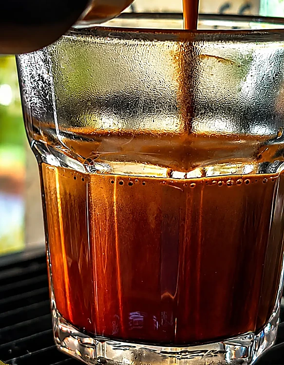 Espresso cayendo en un vaso de vidrio