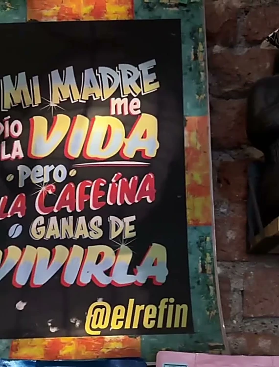 Letrero pintado: Mi madre me dio la vida, pero la cafeína, ganas de vivirla